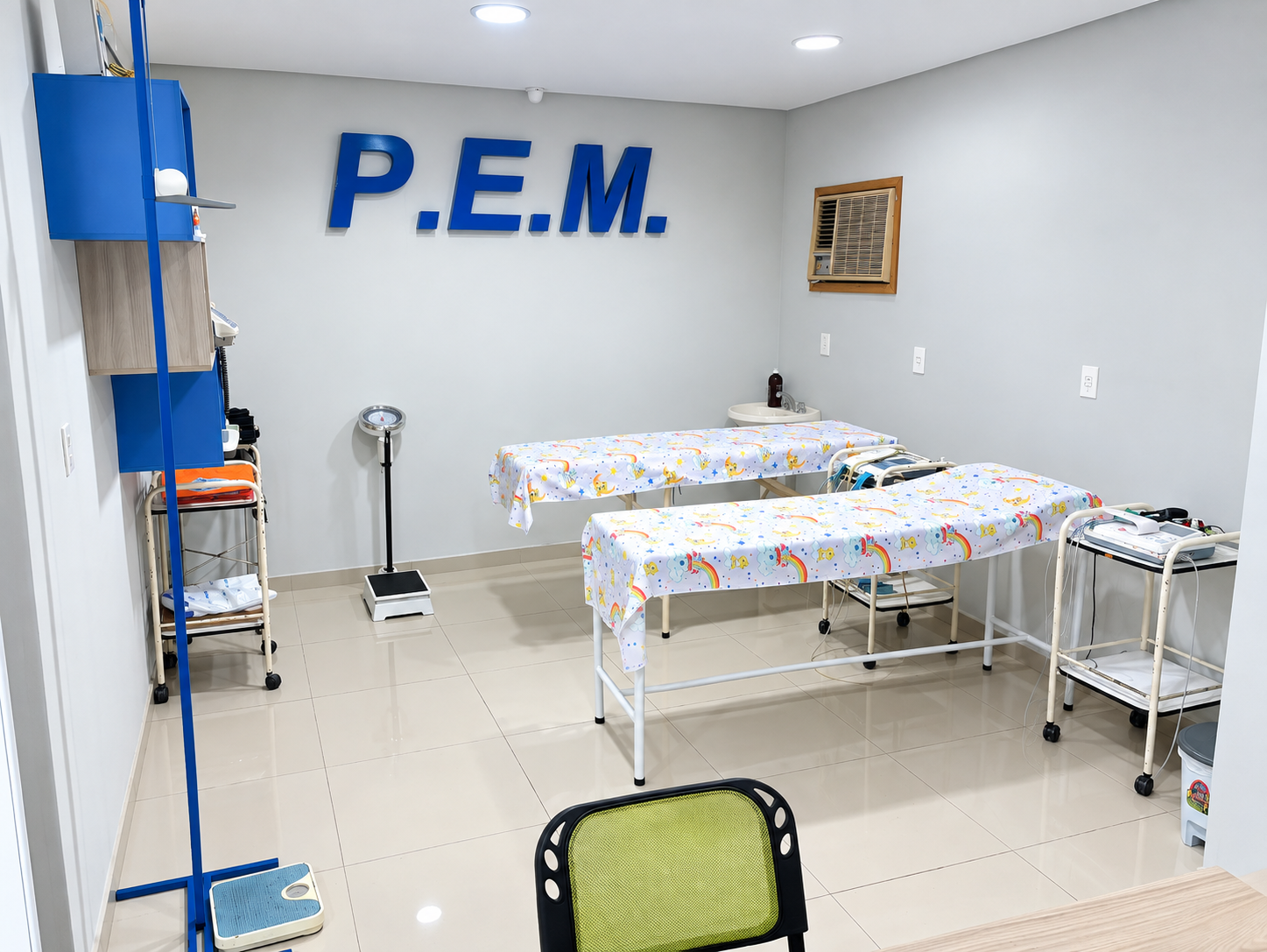 Consultorio de PEM en Fernando de la Mora, con camillas de exploración y el logo P.E.M. en la pared